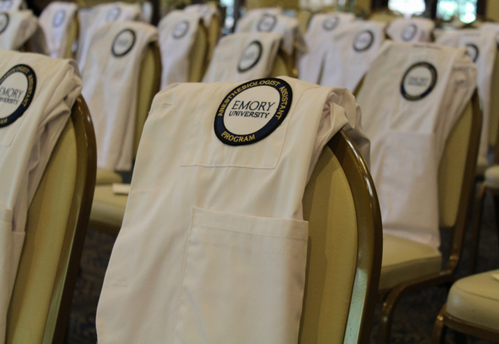 scrub uniforms with the Emory University logo on the front, placed across an array of chairs